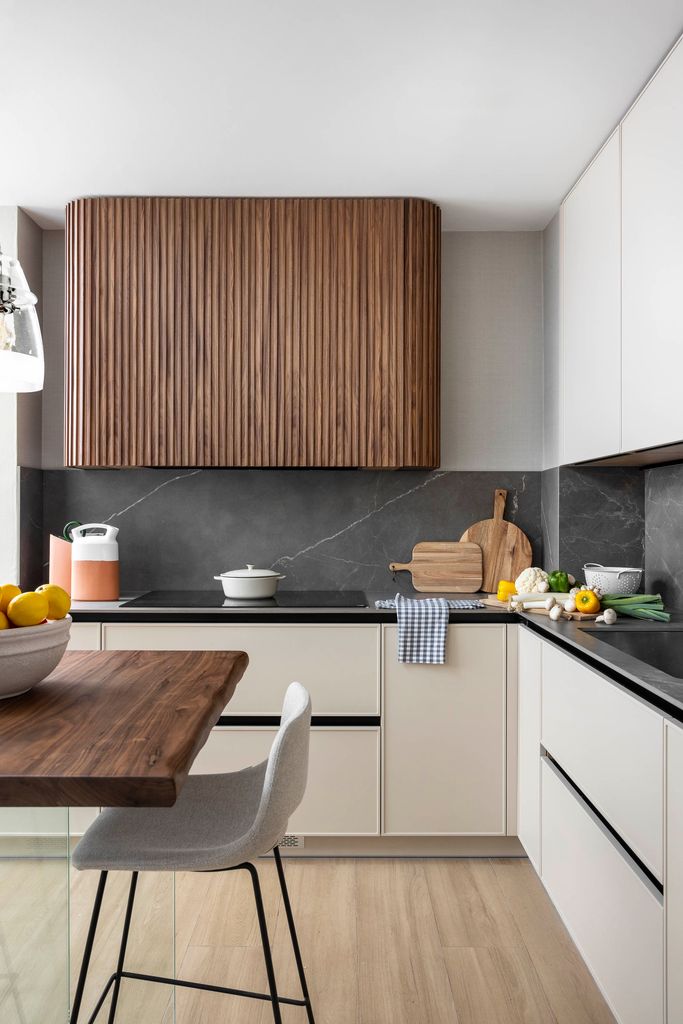 Cocina con muebles blancos y encimera oscura. 