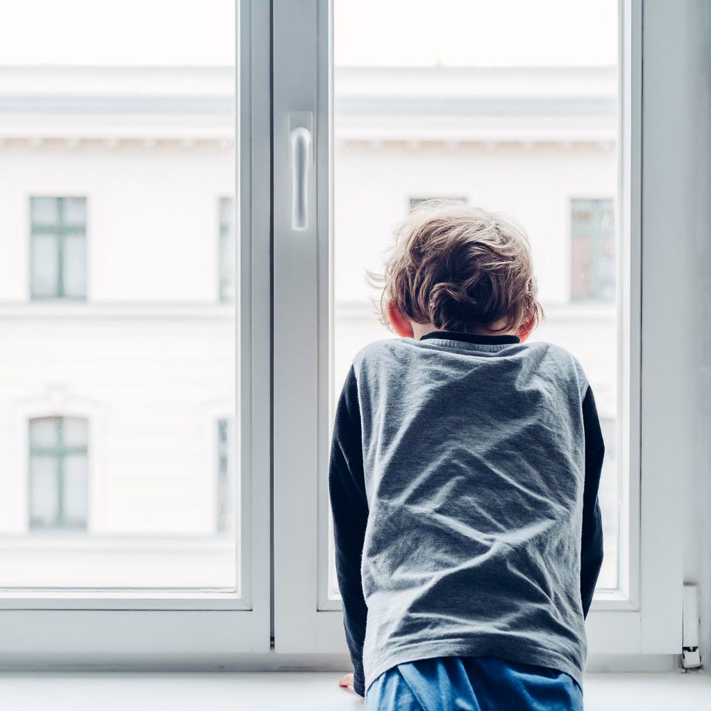 Niño mira por la ventana