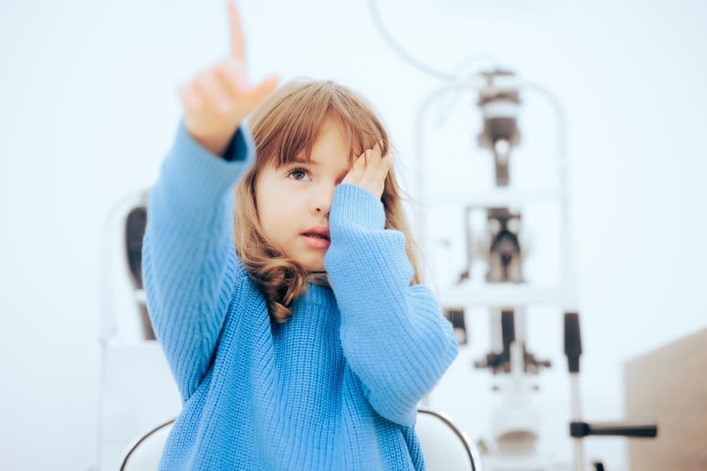 Niña tapándose el ojo en consulta de oftalmología