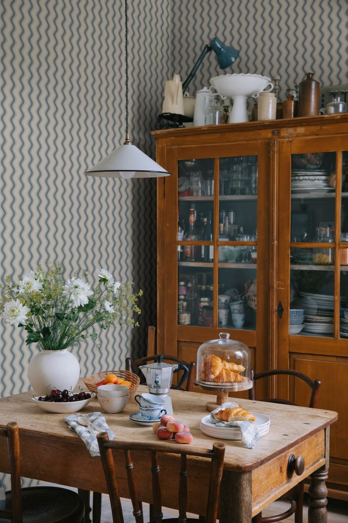 Comedor con papel pintado y vitrina de madera