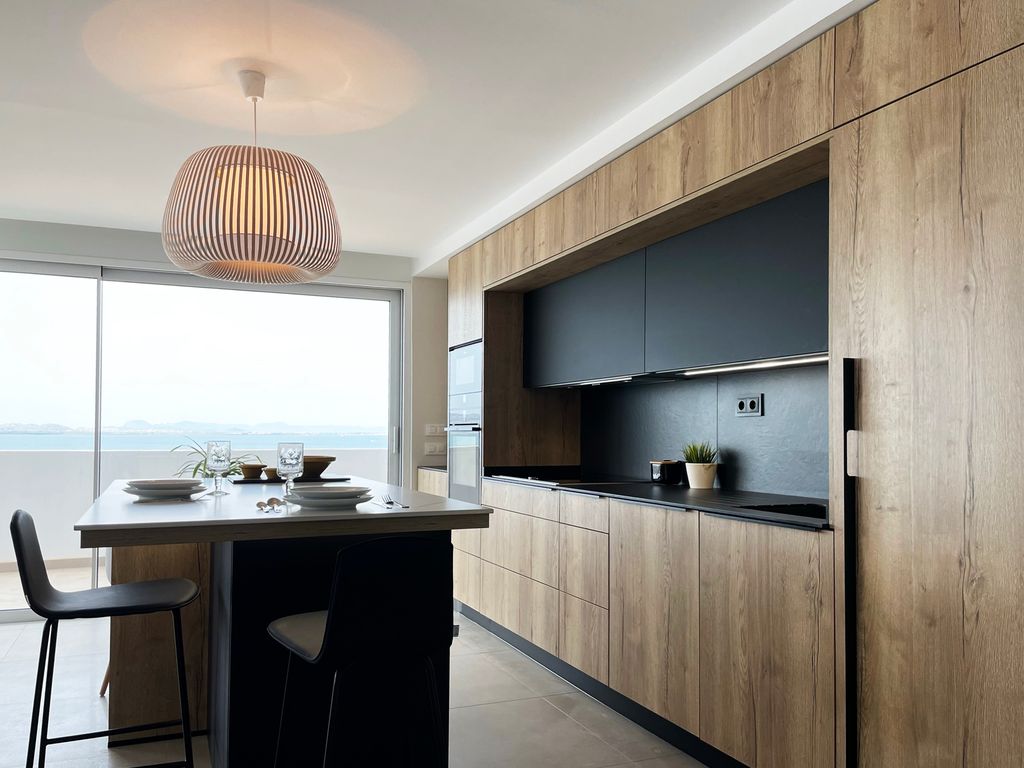 Cocina con muebles de madera y frontal en negro