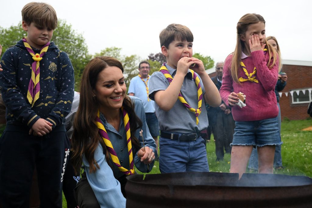 Kate Middleton y sus dos hijos pequeños, Charlotte y Louis, comiendo galletas con marshmallow en un acto infantil