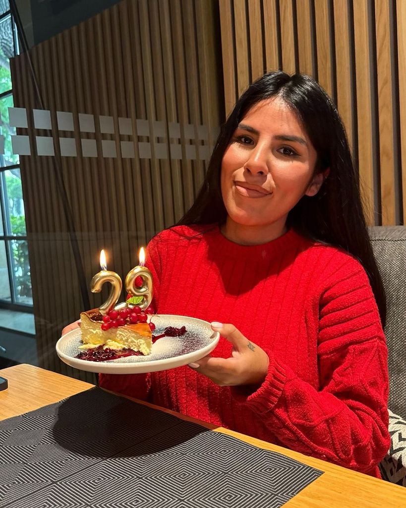 Plano medio de Isa Pantoja posando con su tarta de cumpleaños con velas