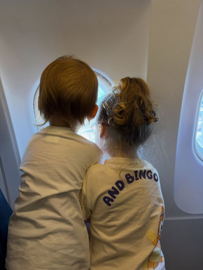 Las niñas mirando por la ventanilla del avión