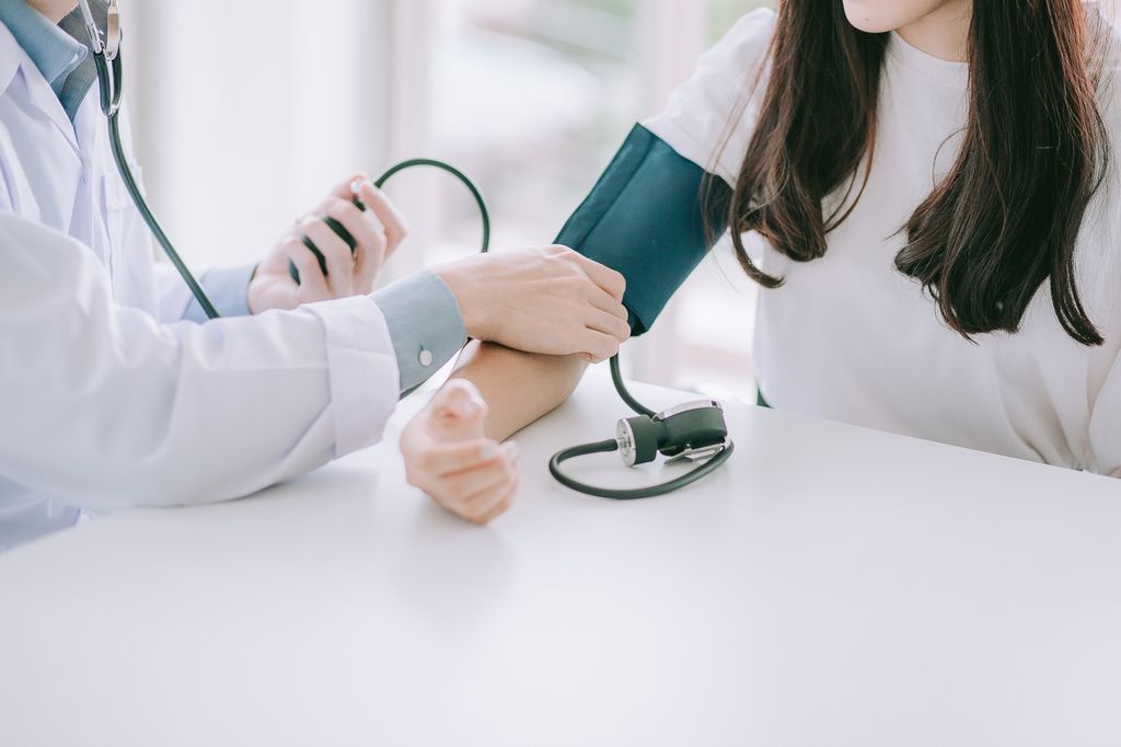 doctor tomando la tensión arterial a una chica joven
