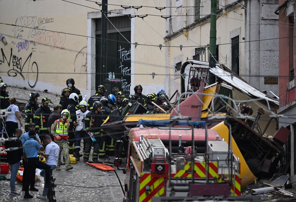 Bomberos y policías trabajan en el lugar del descarrilamiento del funicular de Gloria