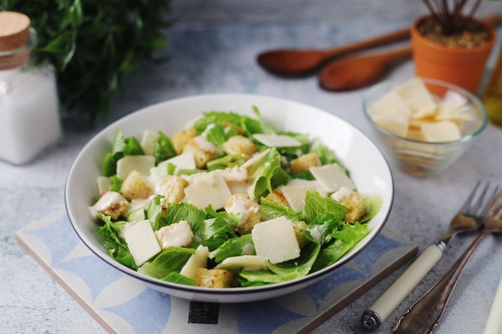 La ensalada César más clásica lleva lechuga, pan y queso, pero no incluye pollo