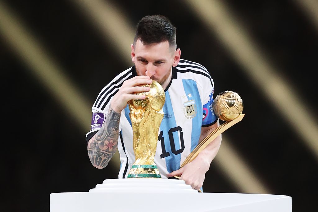 Leo Messi besa el trofeo de campeón de la Copa Mundial de la FIFA Catar 2022 mientras sostiene la Bota de Oro tras la final del Mundial de la FIFA Catar 2022 entre Argentina y Francia, disputada en el estadio Lusail el 18 de diciembre de 2022 en Lusail City, Catar