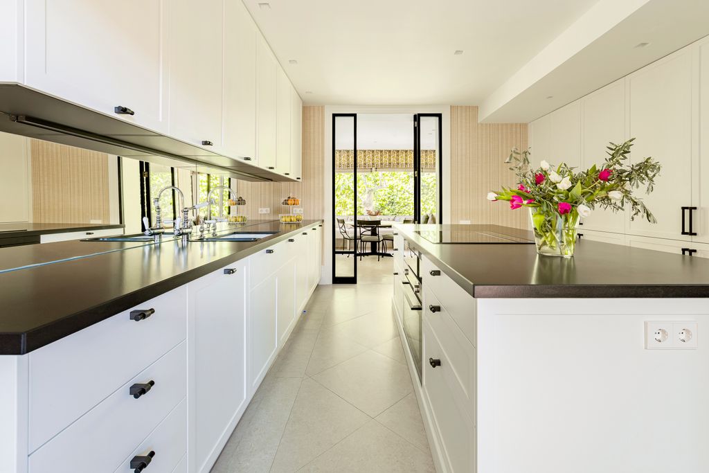Cocina con muebles blancos y encimera negra