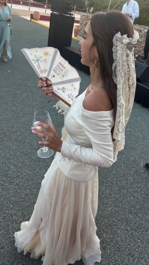La novia utilizó un bonito abanico con un mensaje bordado en colores