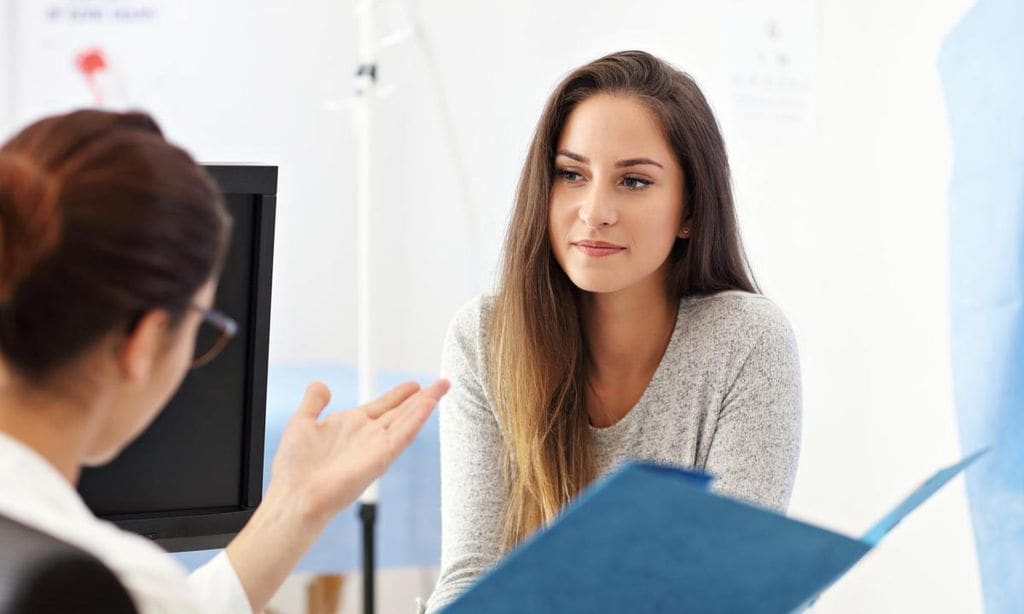 doctora explicando historial a mujer en la consulta