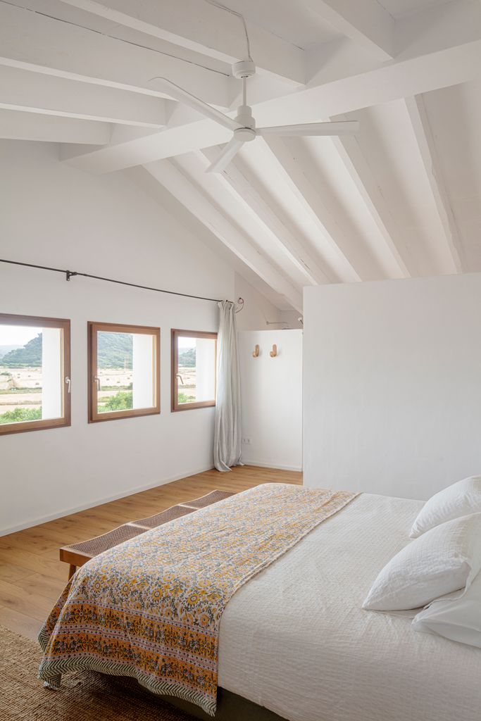 Dormitorio blanco con techo de vigas vistas