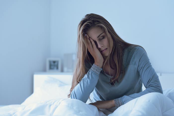 mujer sin poder dormir en la cama