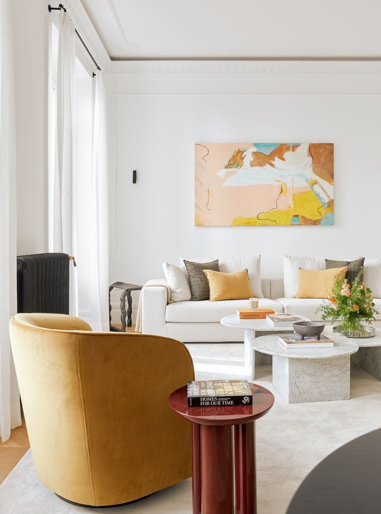 Salón con sofá blanco y obra de arte en tonos pastel