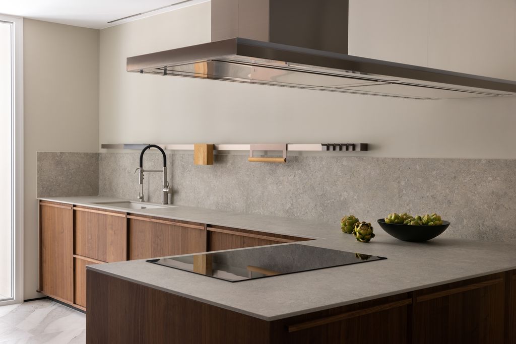 Cocina con muebles de madera y encimera de piedra.  