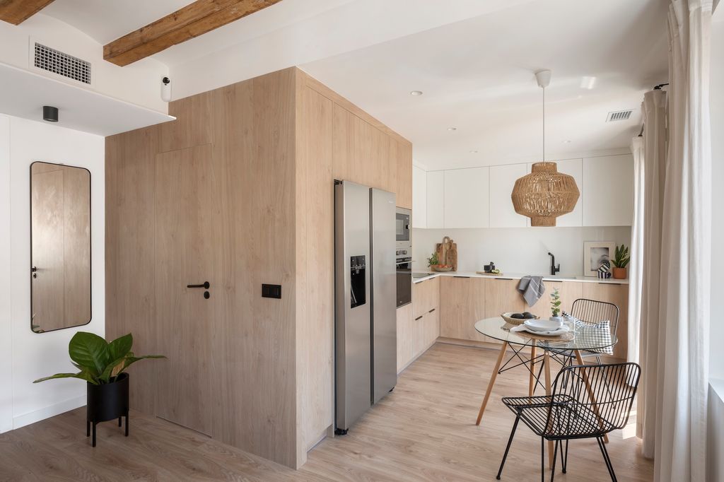 Cocina con paredes y puerta de madera que da acceso al baño 