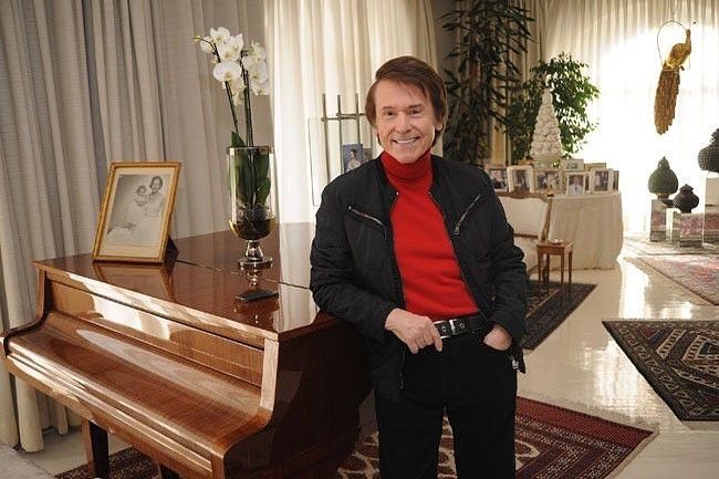 El artista Raphael posa en el piano de su casa