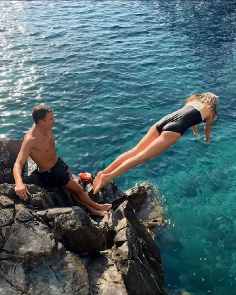 Tom Brady  con su hija Vivian saltando de una roca