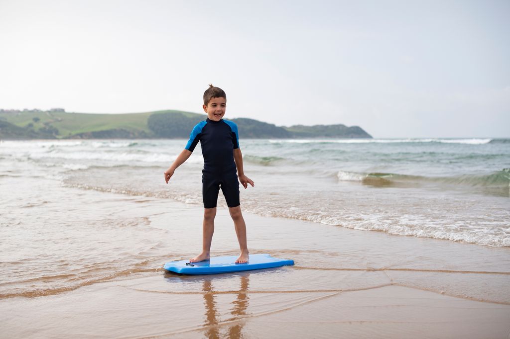 niño haciendo surf en la playa