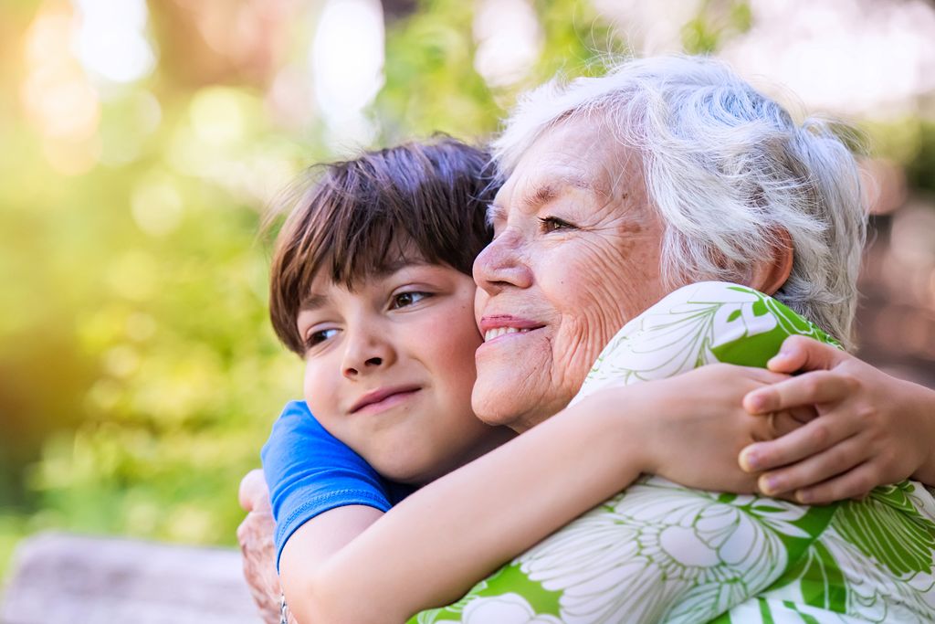 abuela sonriente abrazando a su nieto