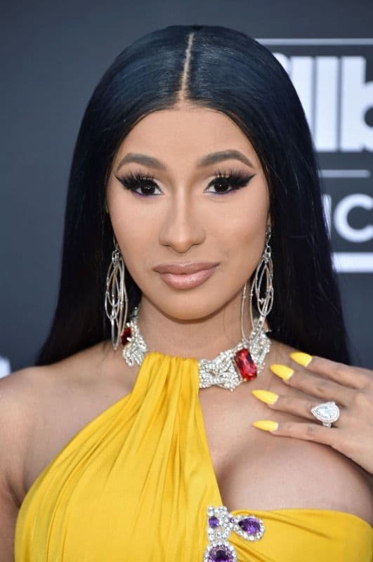Cardi B con cabello suelto, lacio y vestido amarillo 