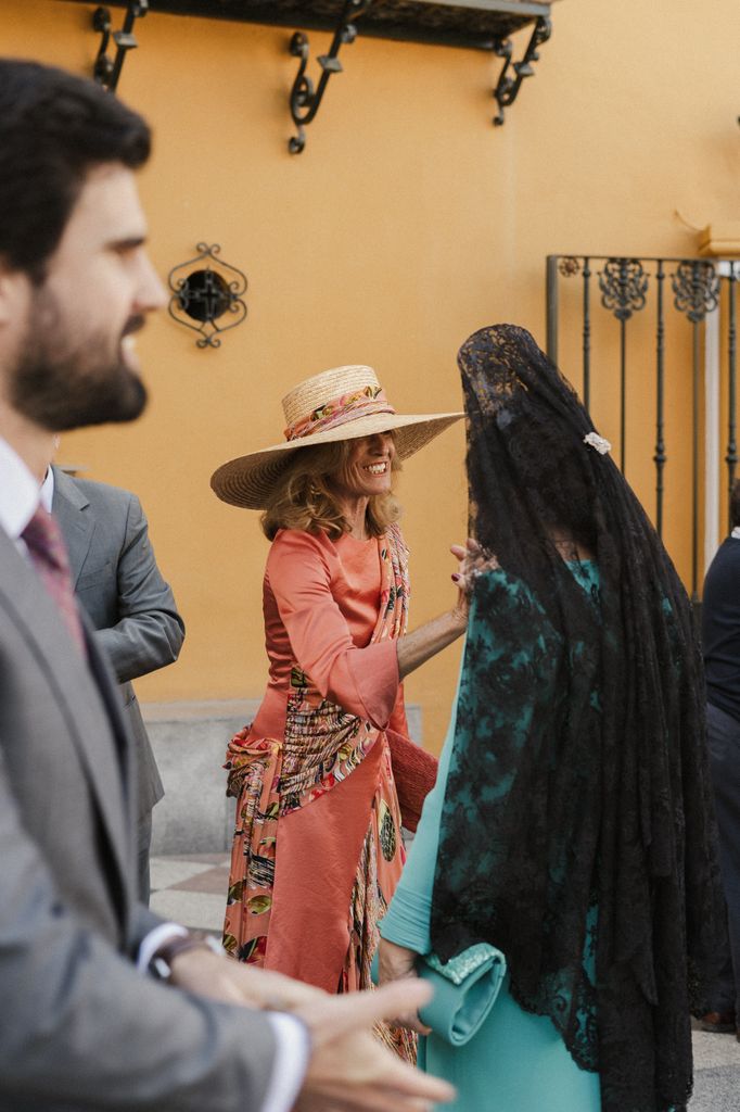 madre de la novia coral con pamela de rafia Boda en Sevilla
