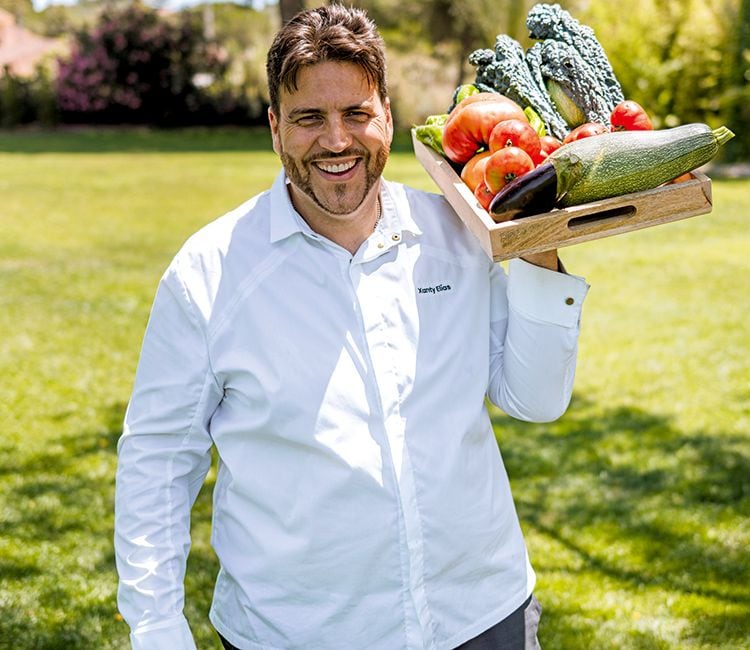Cocinero Xany Elías con una cesta de vegetales