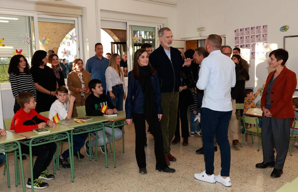 Plano entero de los reyes Felipe y Letizia conversando con responsables del centro