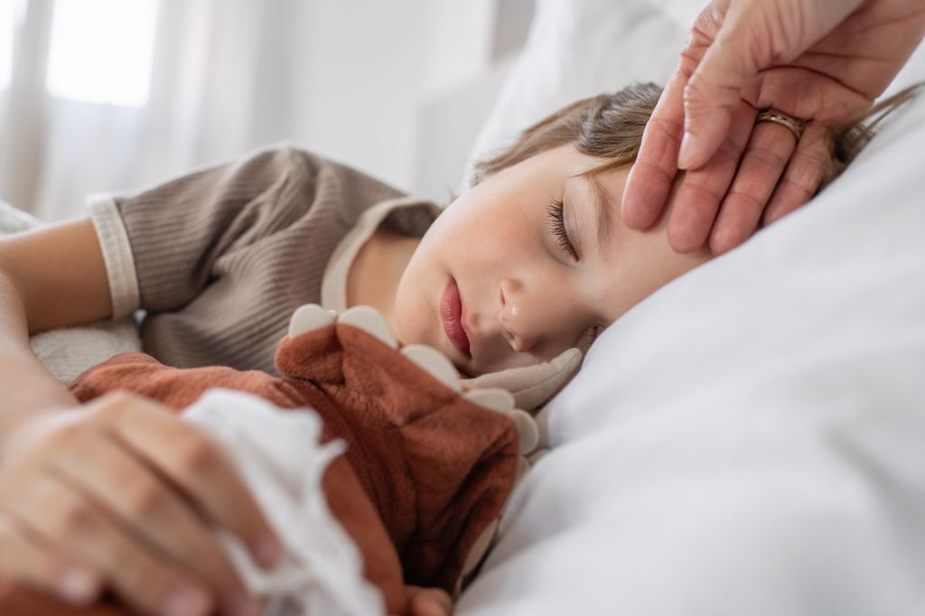 Niño en la cama con fiebre
