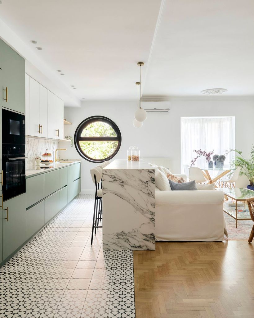 Cocina con muebles verdes abierta al salón