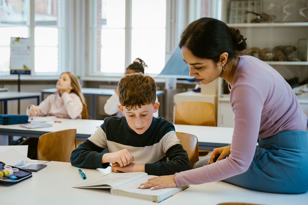profesora junto con un niño en el aula