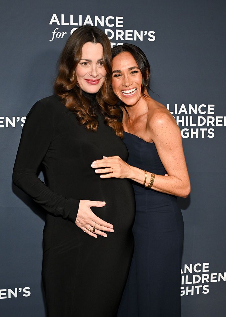 Kelly McKee Zajfen y Meghan Markle posan sonrientes 