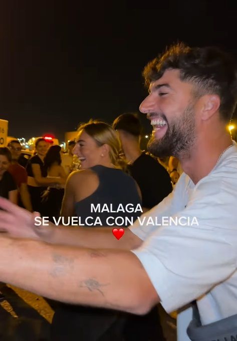 Plano medio de Natalia Palacios y Carliyo llenando furgonetas con donaciones para Valencia