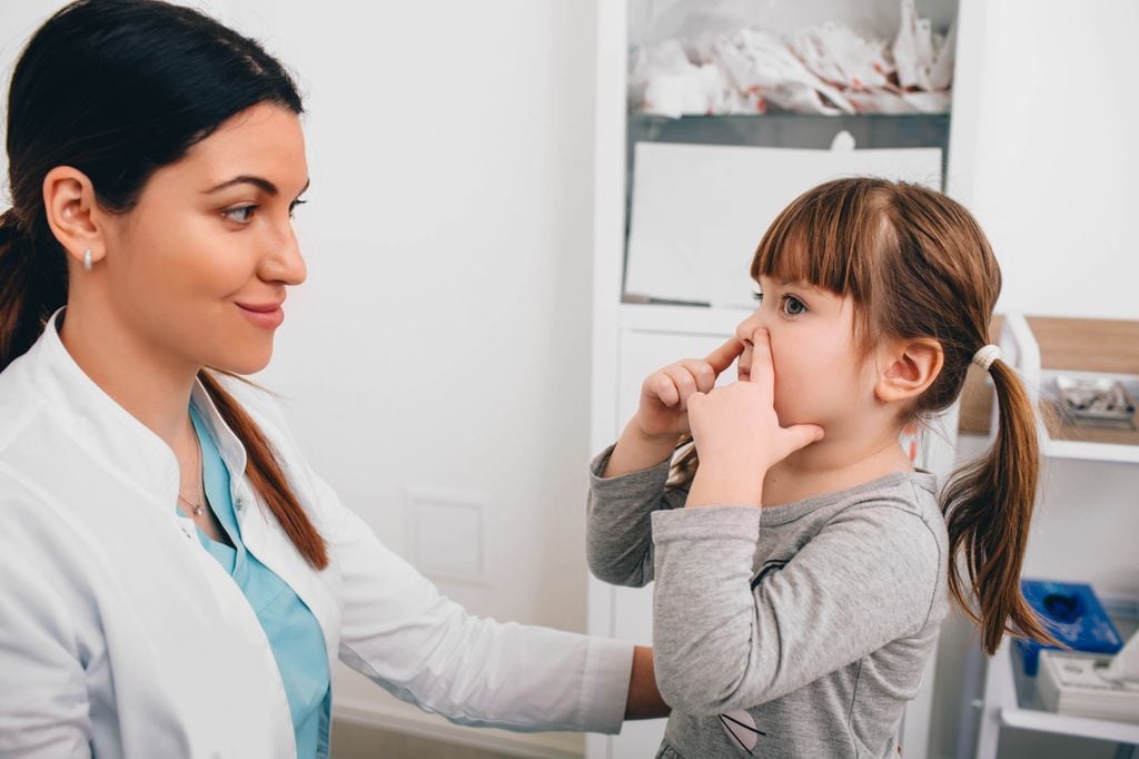 Niña con sinusitis en consulta de pediatra 