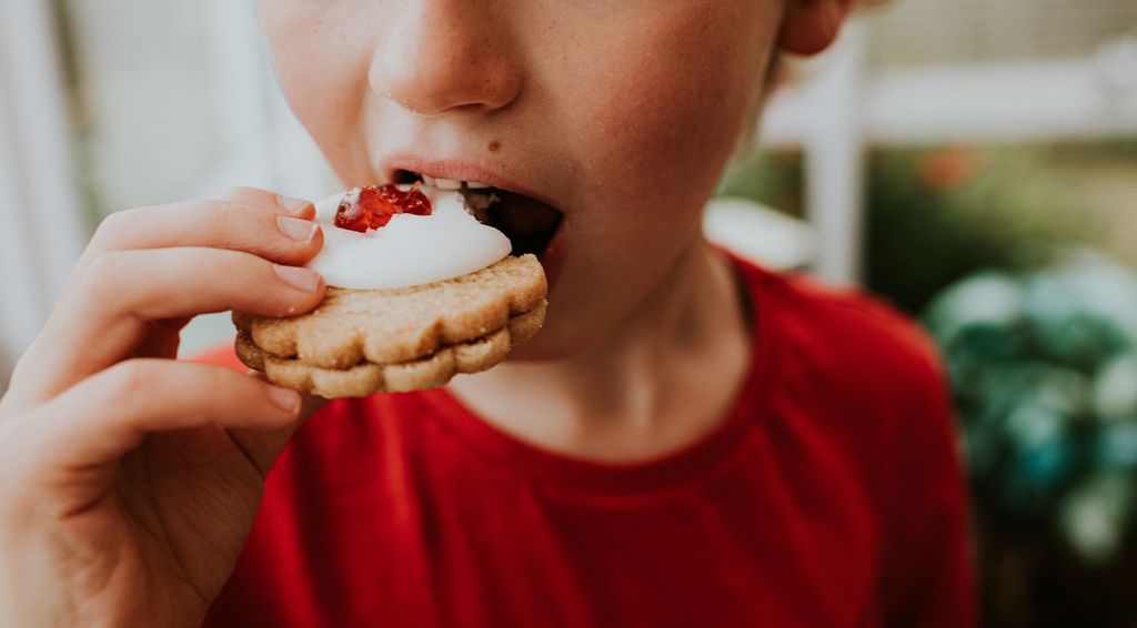Niño comiendo un dulce con azúcar