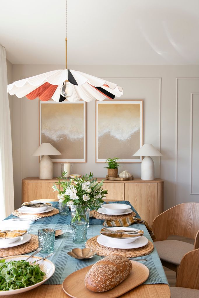 Mesa de comedor decorada con un jarrón con flores. 