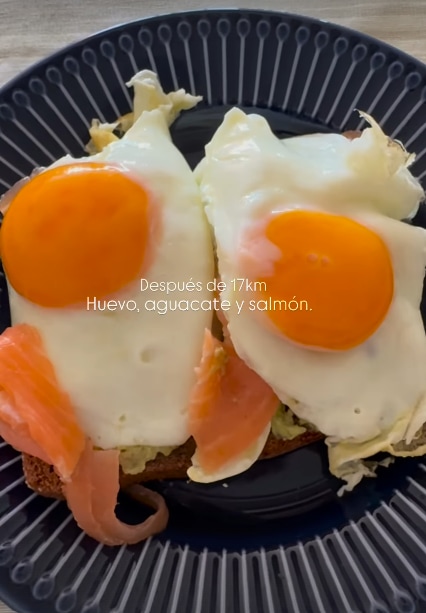 Un plato con huevos, salmón, aguacate y tostadas