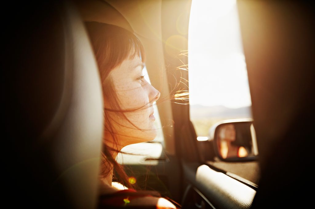 Mujer mira por la venta del coche 