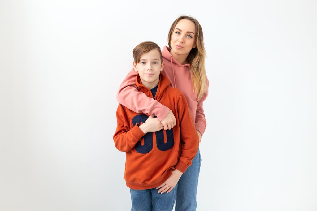 Madre abrazando a su hijo adolescente
