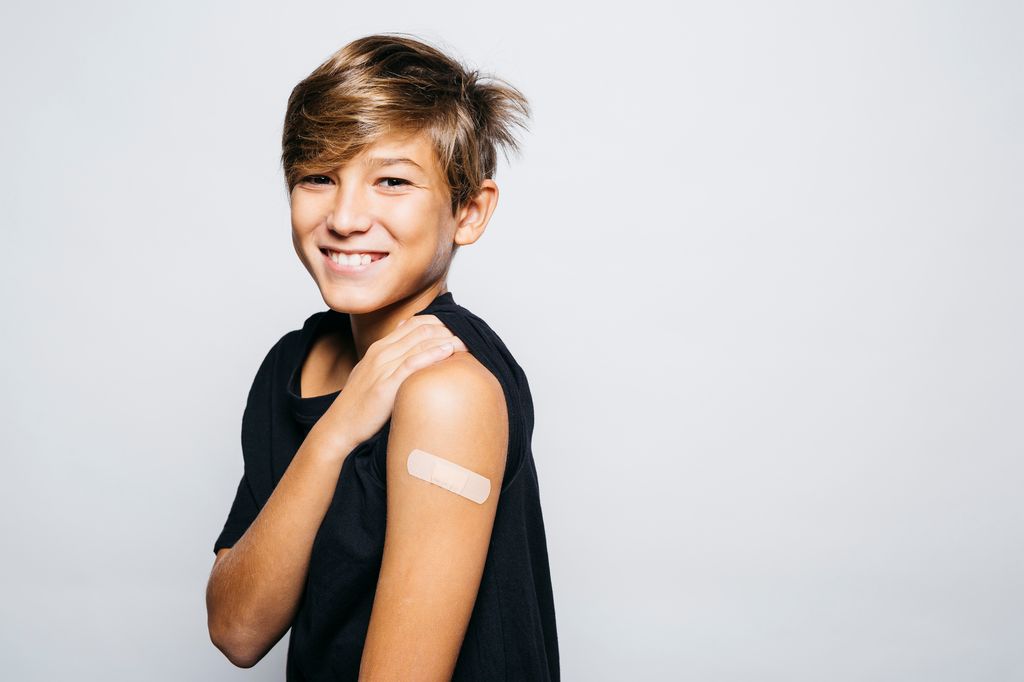 Adolescente enseñando un brazo tras vacunarse