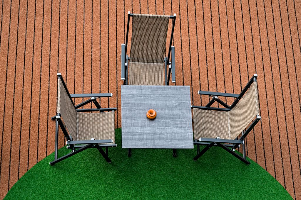 Comedor de verano con una parte del pavimento a base de césped artificial