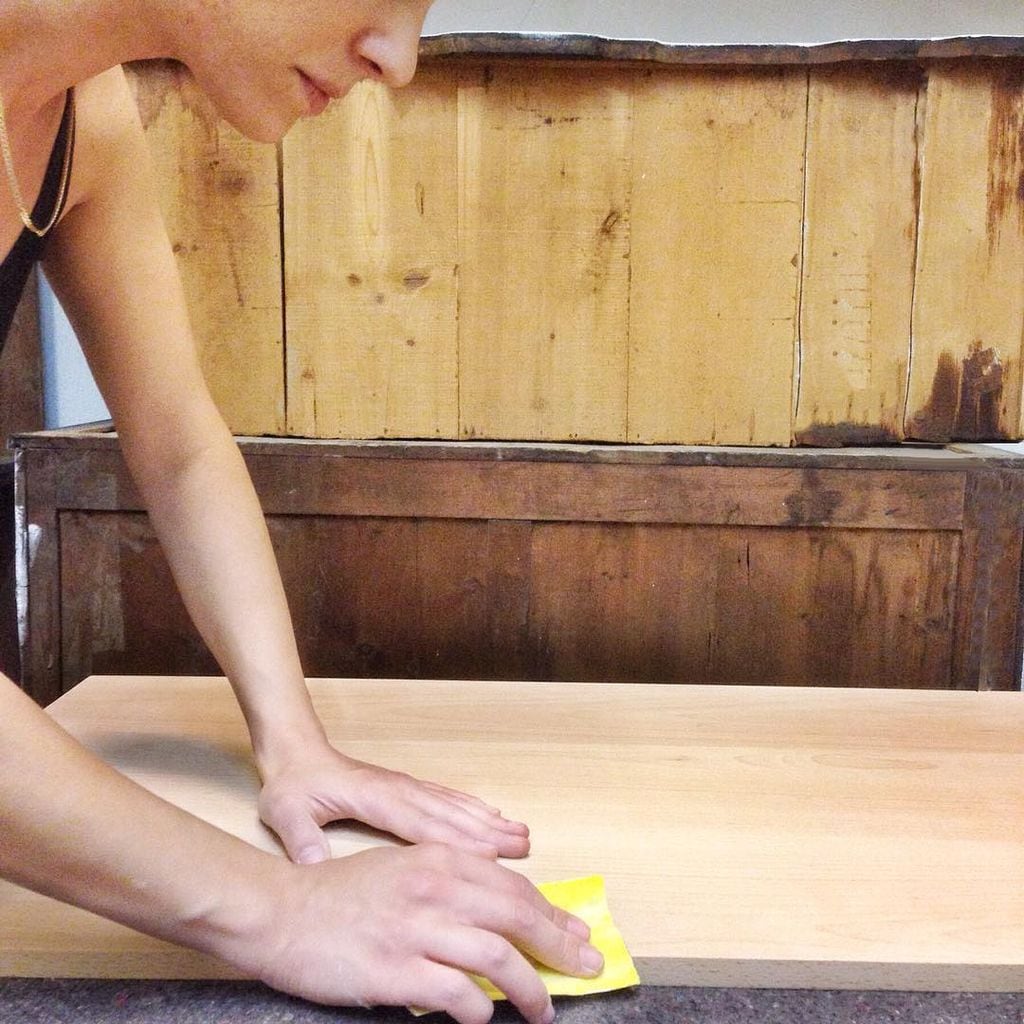 Mujer restaurando un mueble. 