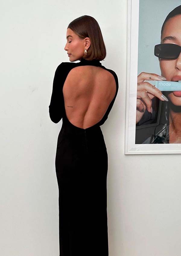 Hailey Bieber con vestido negro de escote en la espalda