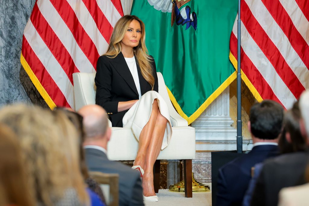 Melania Trump con vestido blanco satinado y americana negra