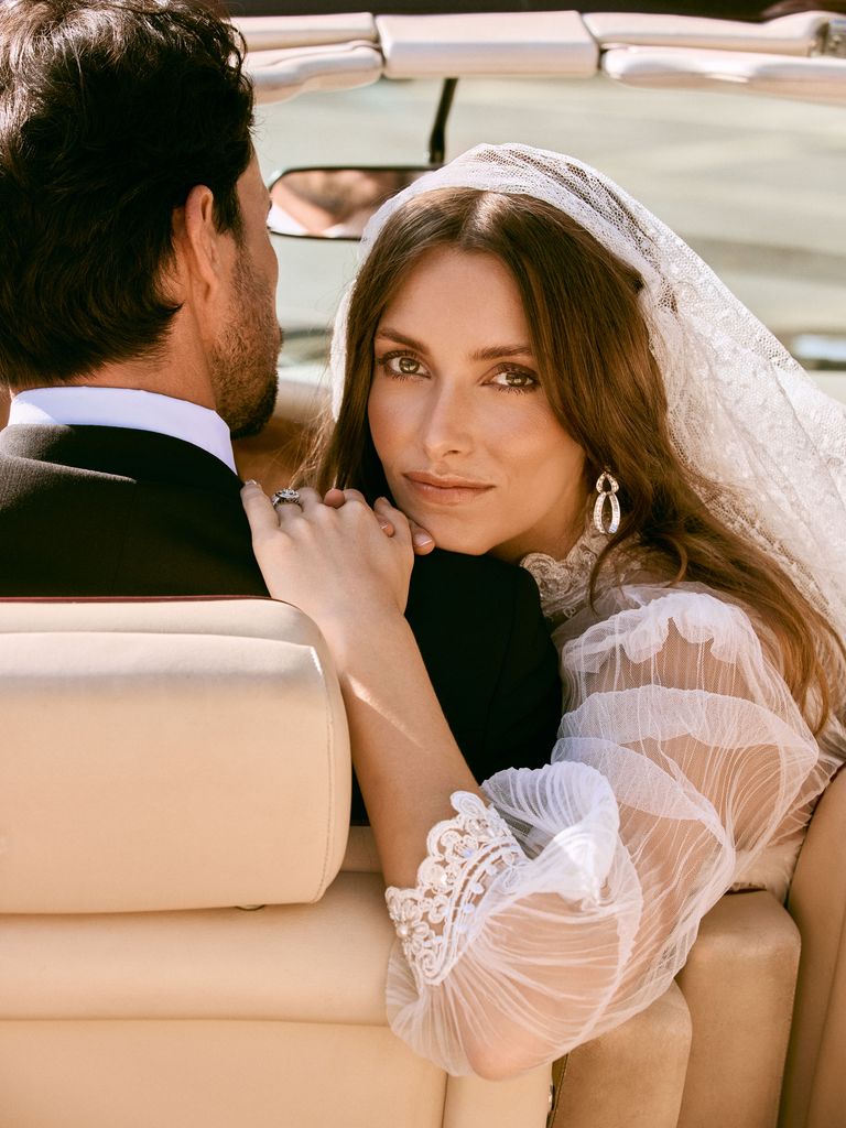 La modelo lleva vestido con mangas de gasa y detalles bordados en cuello y puños, de María Baraza; pendientes en oro blanco y diamantes, de Ansorena, y velo de encaje de Mimoki