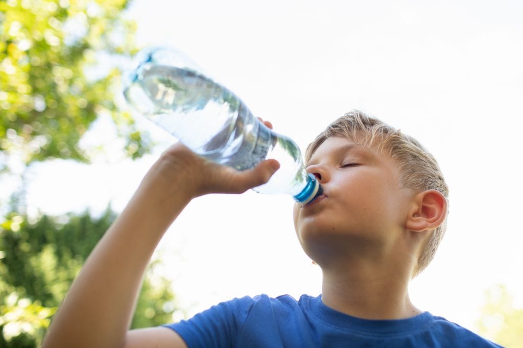 Niño bebiendo agua por riesgo de golpe de calor