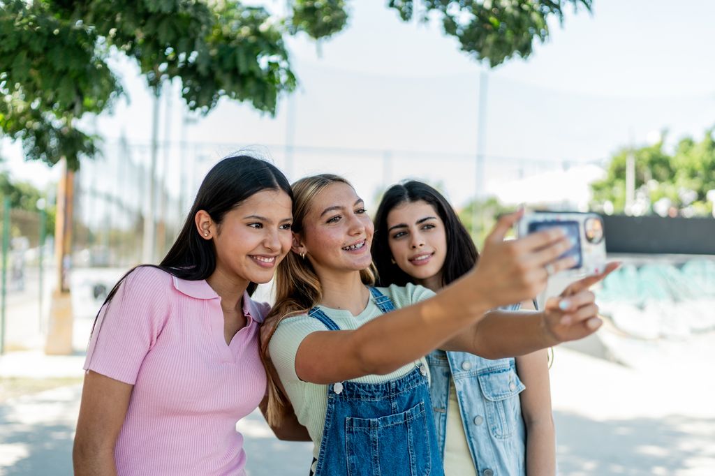 chicas adolescentes haciéndose un selfie en la calle