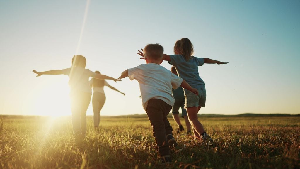 Niños corriendo libres por la naturaleza al atardecer