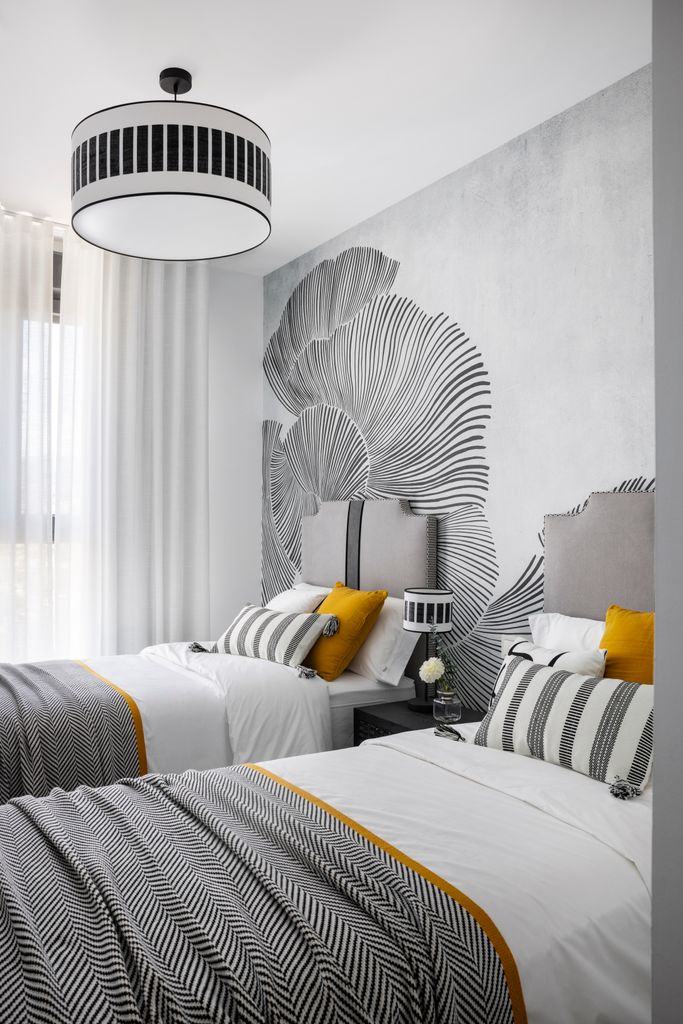 Dormitorio con dos camas decorado en grises, blaco y amarillo