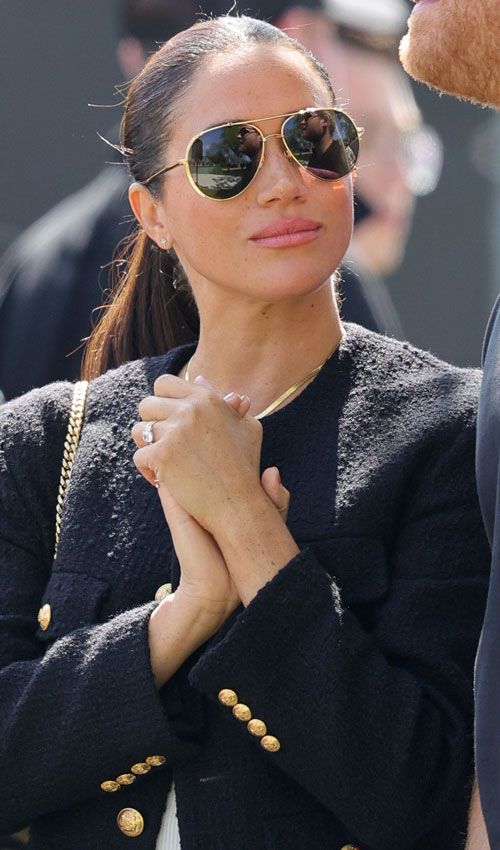 Meghan Markle con chaqueta de tweed negra y gafas de aviador